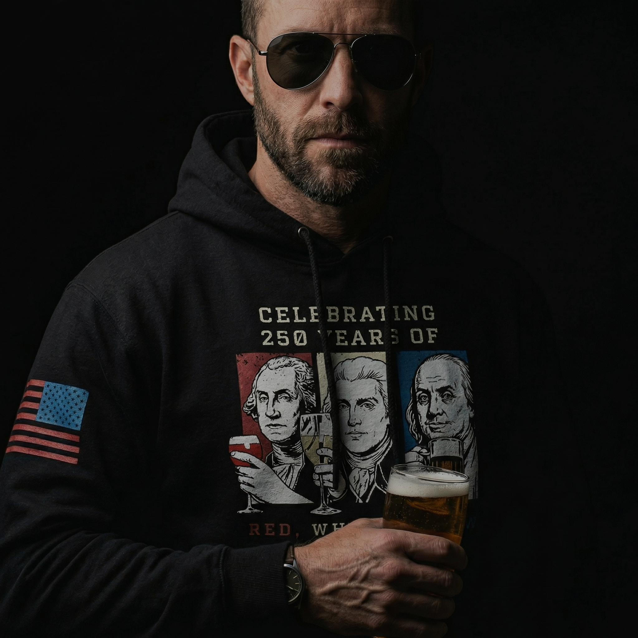 Man wearing a black Red White and Brew 250 years patriotic hoodie with founding fathers drinking graphic