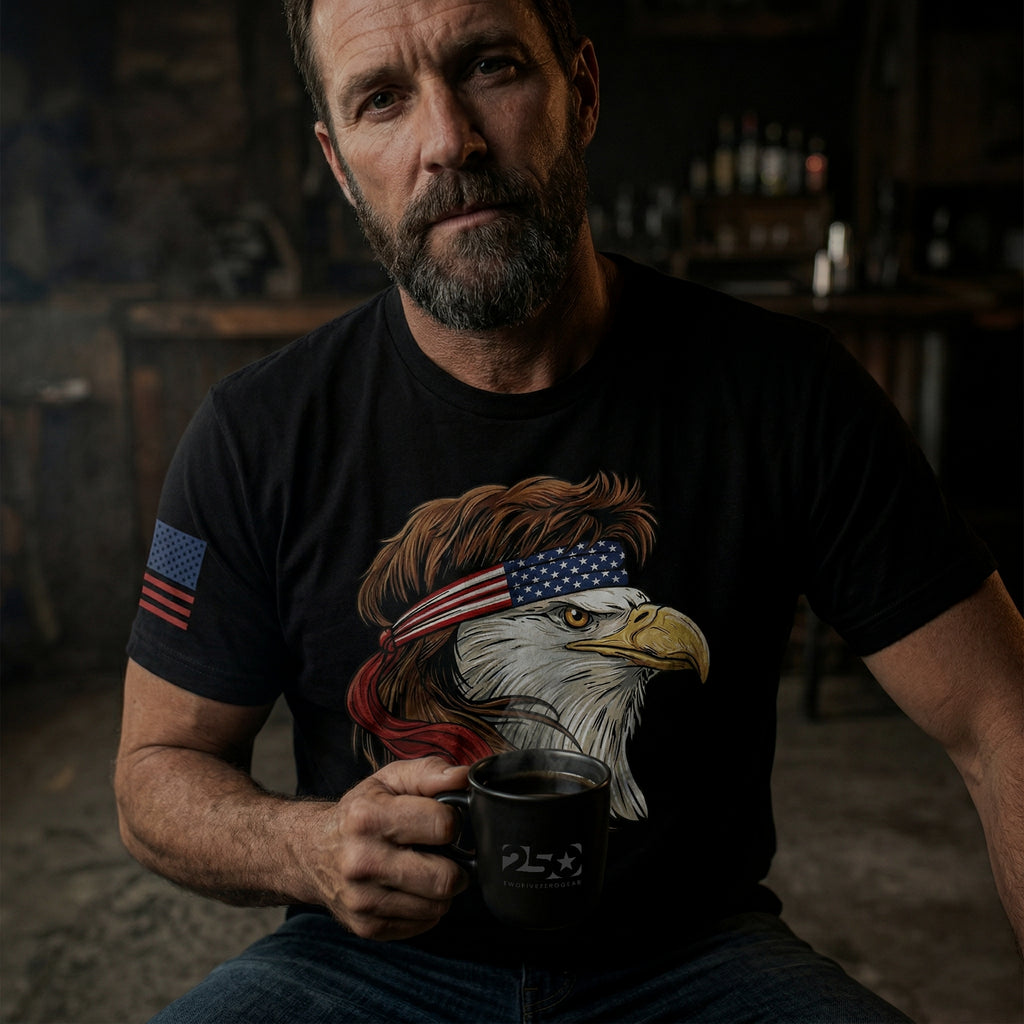 Man wearing a black t-shirt featuring a stylized bald eagle with a mullet hairstyle and American flag headband, symbolizing patriotic pride, with a subtle American flag on the sleeve.